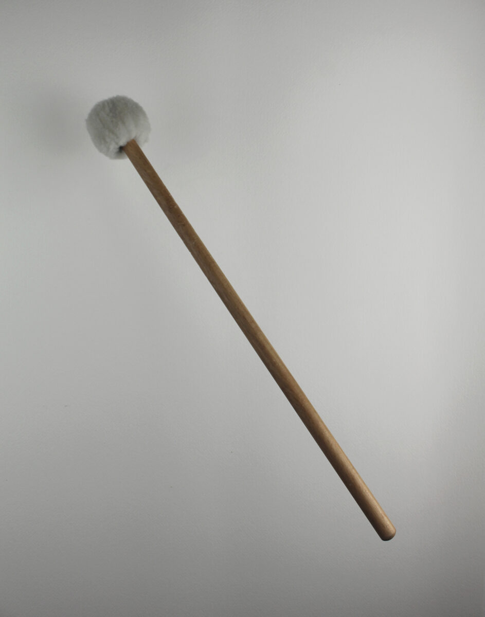 photograph of white mallet captured the instant before making contact with a white wall